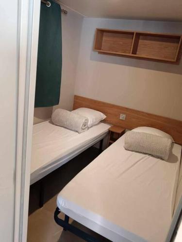 Cette petite chambre comprend 2 lits. dans l'établissement Mobil Home Bouginvilliers 2, à Valras-Plage