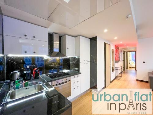 une cuisine avec un évier et une cuisinière four supérieur dans l'établissement Urban Flat 129 - Art Love Champs-Elysees, à Paris