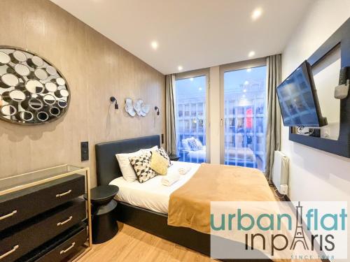 une chambre avec un lit, une télévision et une fenêtre dans l'établissement Urban Flat 129 - Art Love Champs-Elysees, à Paris