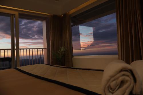 a bedroom with a bed and a window with a view at The Clouds End in Devikolam