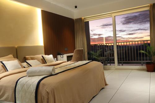 a hotel room with two beds and a balcony at The Clouds End in Devikolam