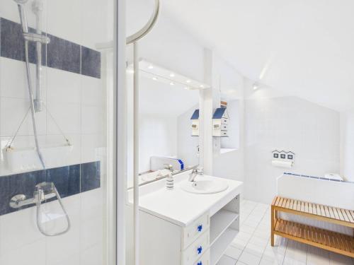 une salle de bain blanche avec une douche et un lavabo dans l'établissement Maison pour 10 personnes avec grand extérieur, à Plomeur