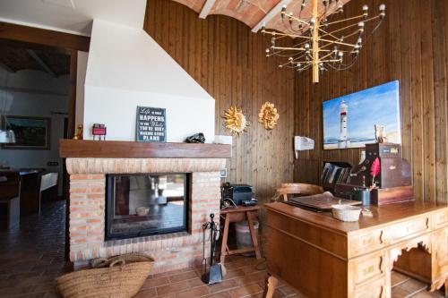 a living room with a brick fireplace and a chandelier at Masia Tinet in Deltebre