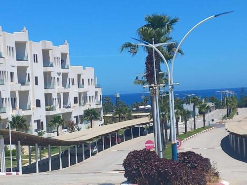 a street light next to a building with a palm tree at Fantástic apartment the beach marina 2 in Tetouan
