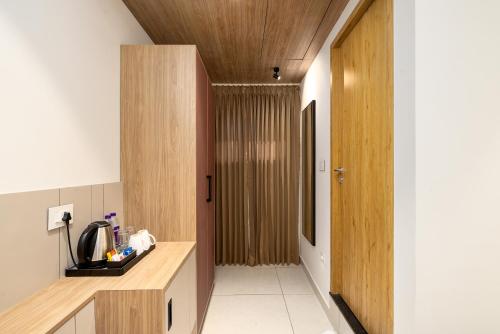 a kitchen with a wooden counter and a hallway at Nexstay Time Square in Kozhikode