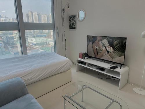 a bedroom with a bed and a tv on a table at Grape Residence Hotel in Incheon