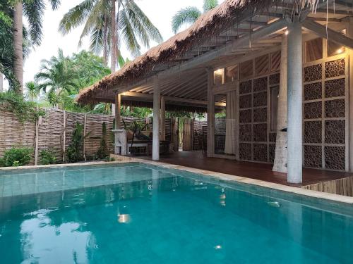 eine Villa mit Swimmingpool und ein Haus in der Unterkunft Villa Ibu gili trawangan in Gili Trawangan