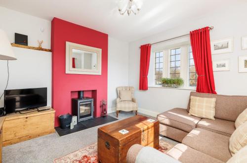 sala de estar con sofá y chimenea en The Old Abbey Farmhouse - Stay at Quarr Abbey Monastery - Pet-Friendly Farmhouse with History & Countryside Views, surrounded by woodland & nature, en Ryde