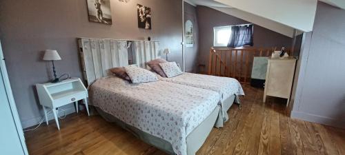 una camera da letto con un letto e un tavolo con un comodino di Le Pavillon de Chasse a Saint-Agnan-le-Malherbe