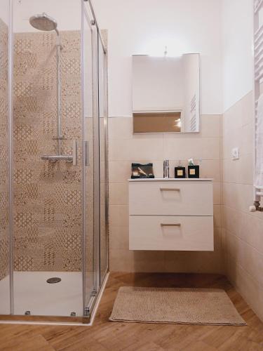 a bathroom with a shower with a sink and a mirror at Dimora Gemella in Castellana Grotte