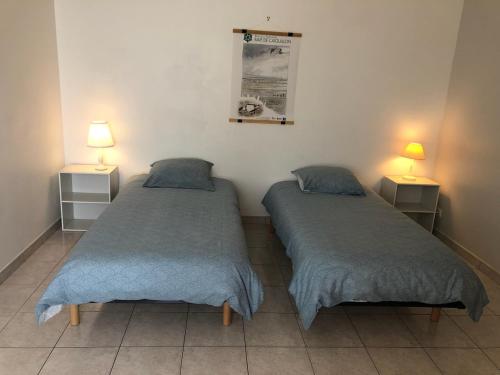 - 2 lits dans une petite chambre avec 2 lampes dans l'établissement maison de pêcheur face à la plage du plan d'eau, à LʼAiguillon-sur-Mer
