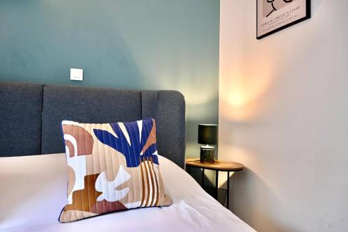 - un lit avec une tête de lit bleue et un oreiller dans l'établissement Appartement proche centre avec terrasse, à Strasbourg