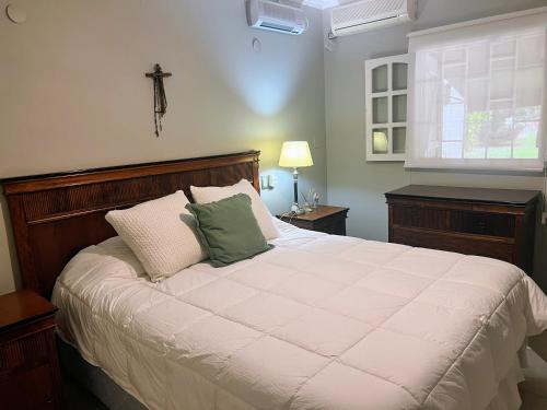 a bedroom with a large bed with a cross on the wall at Casa de categoría para 6 personas in Santiago del Estero