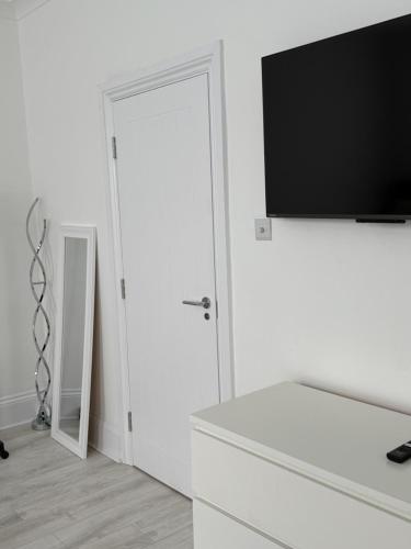 a white room with a flat screen tv on a wall at The Avenue Suite in London