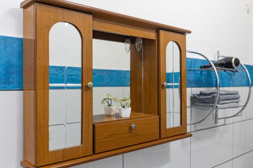 a wooden cabinet with mirrors in a bathroom at Borghetto Nora 5 in Gravina di Catania