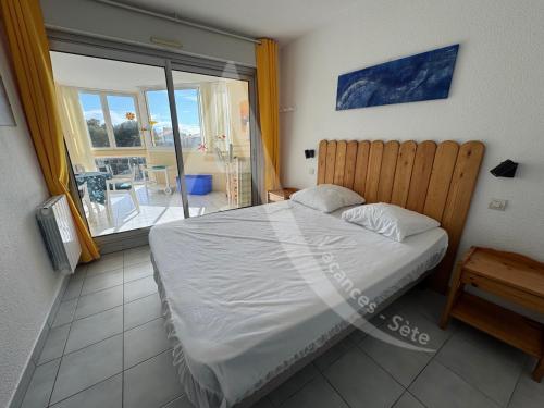 une chambre avec un lit et une vue sur un balcon dans l'établissement SPACIEUX APPT 2 CHAMBRES QUARTIER DES PLAGES, à Sète