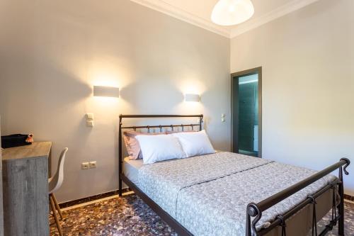 a bedroom with a bed and two lights on the wall at Petrino Serene Studios in Kakóvatos