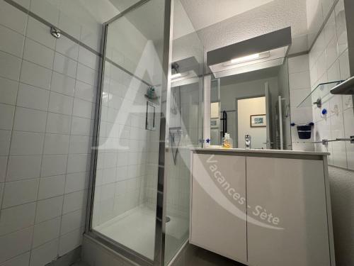 une salle de bain avec une douche en verre et un lavabo dans l'établissement SPACIEUX APPT 2 CHAMBRES QUARTIER DES PLAGES, à Sète