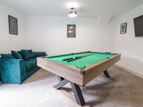 a living room with a pool table and a couch at Threshers Barn in Oswestry