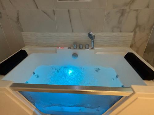 a jacuzzi tub with blue water in a bathroom at Sereni house jacuzzi in Narbonne