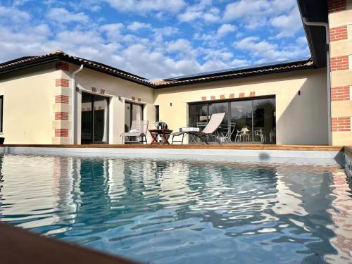 une piscine devant une maison dans l'établissement Villa piscine chauffée golf, à Gujan-Mestras