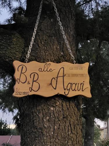 a sign hanging from a tree with the words allsie bennett at b&b ALLE AGAVI in Mereto di Capítolo