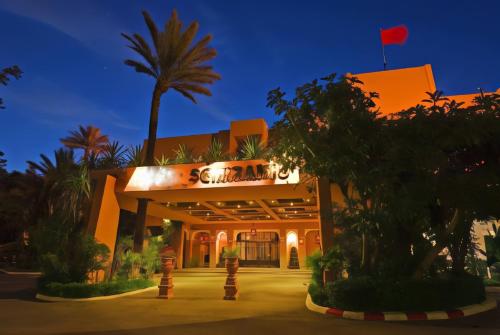 a building with a palm tree in front of it at Hôtel Le Semiramis Marrakech by Bravia Hotels in Marrakech