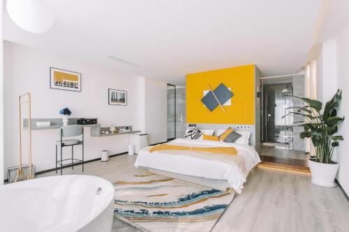 a white bedroom with a bed and a yellow wall at Dali Mermaid Seascape Resort Hotel in Dali