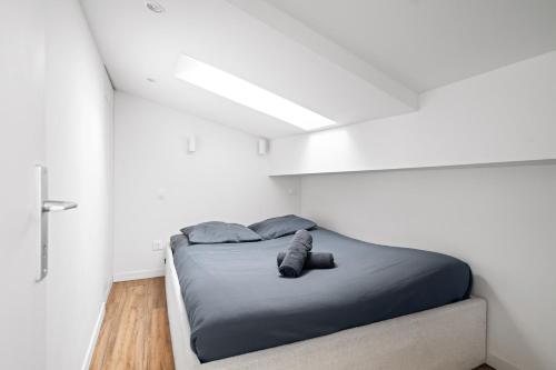 une chambre avec un lit dans une pièce blanche dans l'établissement Vieux Nice - Dernier étage climatisé, à Nice