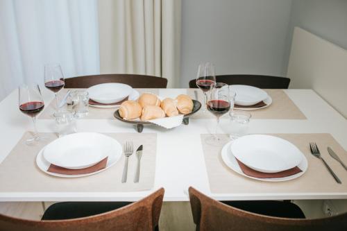 a white table with plates and glasses of wine at Aparthotel Touring in Grado