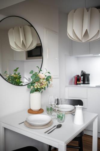 - une cuisine blanche avec une table, des assiettes et un miroir dans l'établissement Vieux Nice - Dernier étage climatisé, à Nice