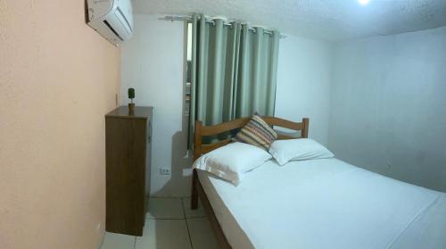 a small bedroom with a bed and a window at Apraiana Pousada e Hostel in Recife