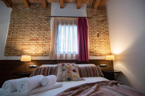 a bedroom with a bed and a window with towels at Masia Tinet in Deltebre