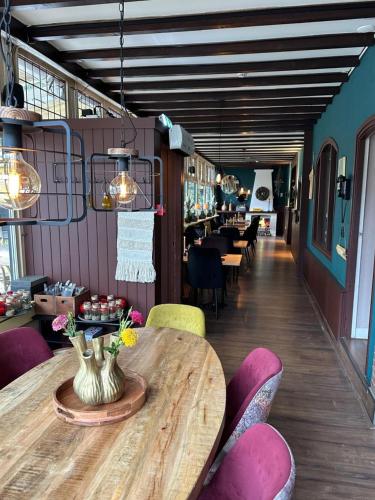 a dining room with a wooden table and chairs at Boutique Hotel de la Ruïne in Valkenburg