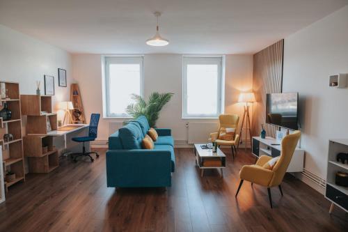 un salon avec un canapé bleu et des chaises dans l'établissement Le rêve Bleu, à Thionville