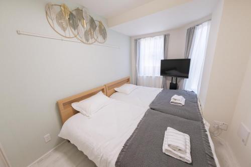 a bedroom with a bed and a television in it at Sumire in Tokyo
