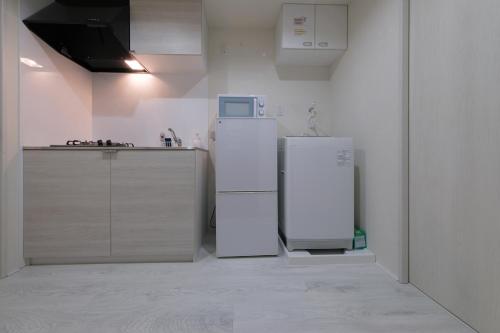 two white refrigerators in a kitchen with a counter at Sumire in Tokyo