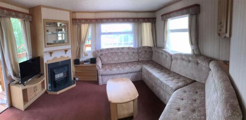 a living room with a large couch and a television at Kubusiowy Zakątek in Ełk