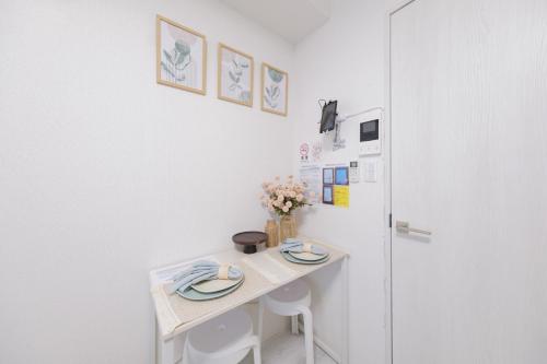 a small white table in a room with a refrigerator at Sumire in Tokyo