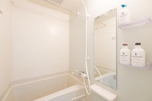 a bathroom with a shower with two bottles of soap at Sumire in Tokyo