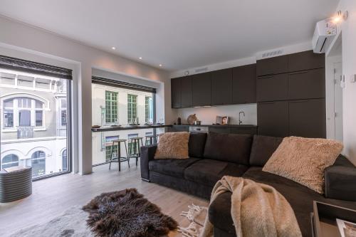 a living room with a couch and a kitchen at Margriet Apart-Suites in Ghent