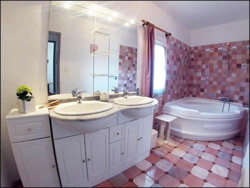 une salle de bain avec deux lavabos et une baignoire et des toilettes dans l'établissement Au jardin de la ferme - gite vigne vierge, à Six-Fours-les-Plages