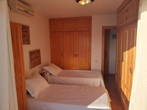 a bedroom with two beds and a closet at Apartamento 335 Flamesol in Matalascañas