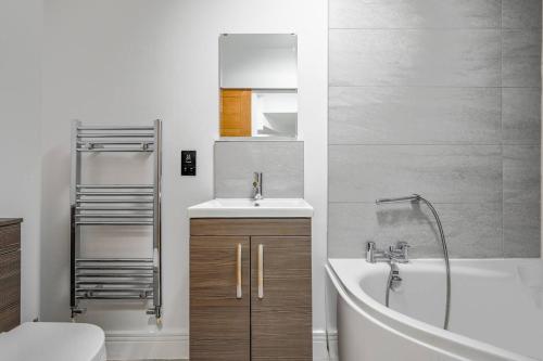 a bathroom with a sink and a tub and a toilet at Luxury 3-Bed house, Beach 300m, Sleeps 6, Parking in Newquay