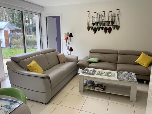 a living room with a couch and a table at Gites La Baie des Remparts Meublé Les Avocettes in Saint-Valery-sur-Somme