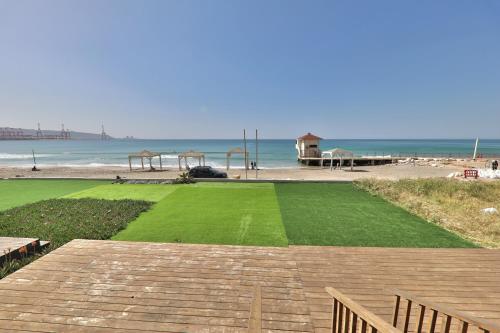 a large grassy field next to the beach at שקיעה בים - דירות יוקרתיות מהממות עם ג'קוזי ונוף לים יש מקלט in Haifa