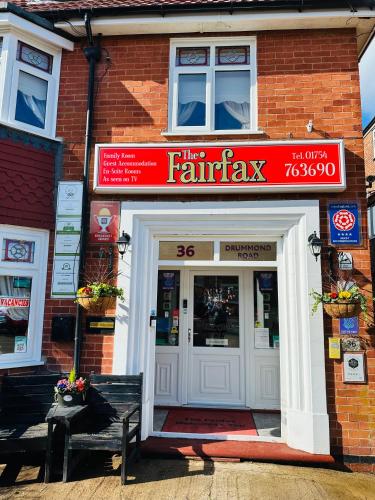a store with a red sign above the entrance to a building at Fairfax in Skegness
