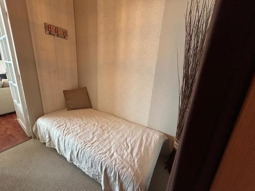 une petite chambre avec un lit dans une pièce dans l'établissement Studio-Cabine PLEINE VUE MER ET EVENTAIL CABOURG, à Cabourg