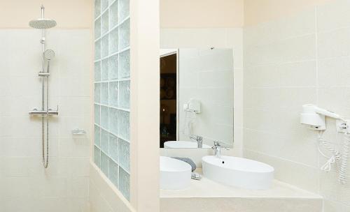 a bathroom with two sinks and a mirror at Relais des Plateaux & Spa– Ivato International Airport in Antananarivo