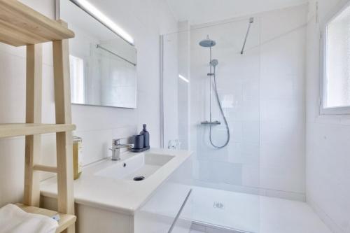 une salle de bain blanche avec un lavabo et une douche dans l'établissement T3 proche de la Croisette et Palais des Festivals, à Cannes